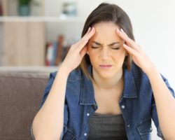 Junge Frau wird von Kopfschmerzen geplagt