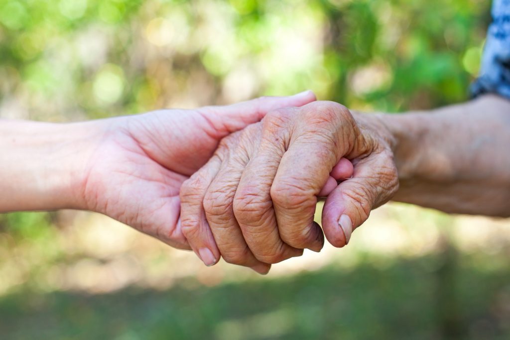 Jüngere hält ältere Hand