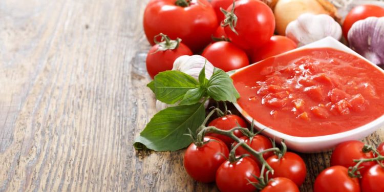 Frische Tomaten, Zwiebeln, Knoblauch und eine daraus zubereitete Tomatensoße