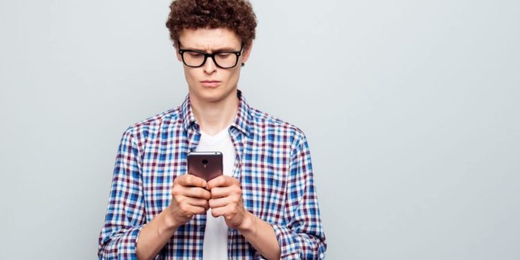 Junger Mann nutzt sein Smartphone