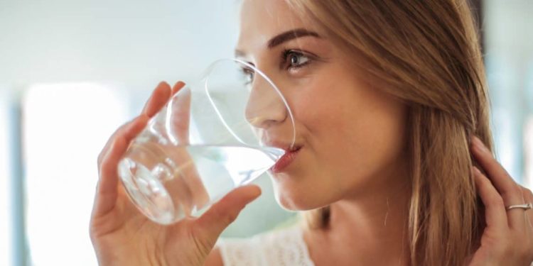 Frau trinkt ein Glas Wasser