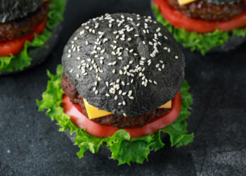 Mit Aktivkohle versetzte Lebensmittel wie Burger liegen im Trend. Experten raten jedoch von den schwarzen Speisen ab. Denn sie können die Wirkung von Medikamenten beeinträchtigen. (Bild: grinchh/fotolia.com)