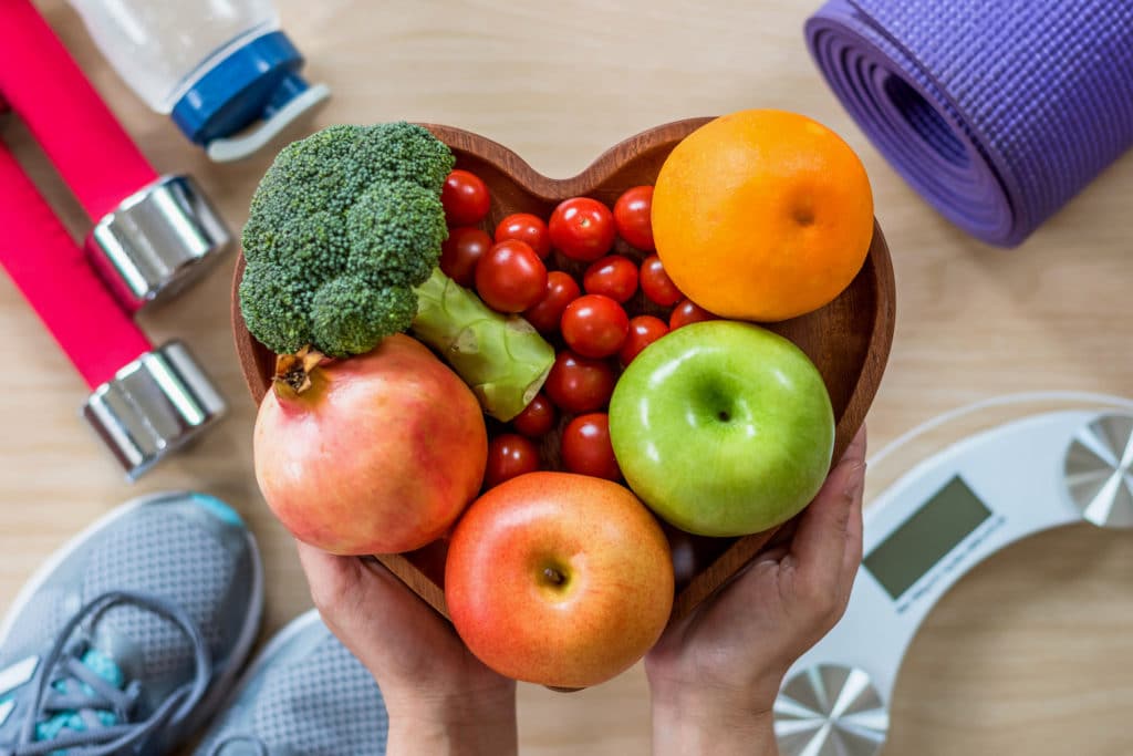 Eine herzförmige Schale, die mit Obst und Gemüse gefüllt ist