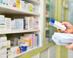 Apotheker nimmt verschiedene Medikamente aus dem Regal