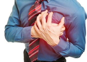 Mann mit Herzproblemen drückt Hände an Brust
