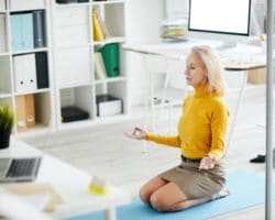 Frau praktiziert Yoga im Büro