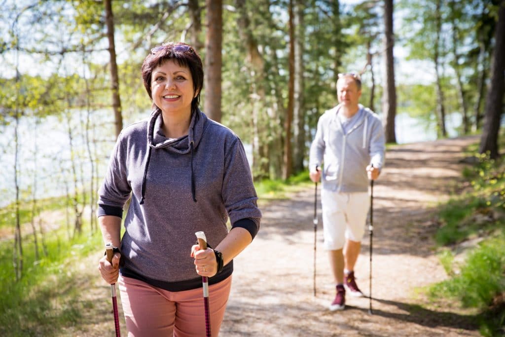 Eine Frau und ein Mann beim Nordic Walking