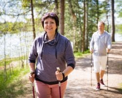 Eine Frau und ein Mann beim Nordic Walking