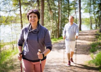 Eine Frau und ein Mann beim Nordic Walking