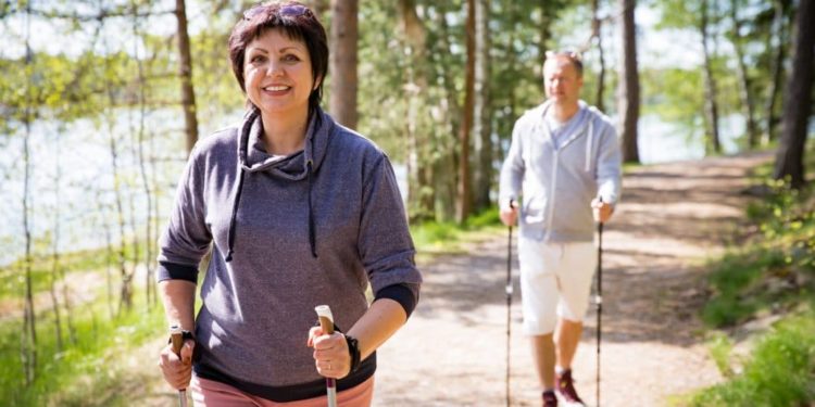 Eine Frau und ein Mann beim Nordic Walking