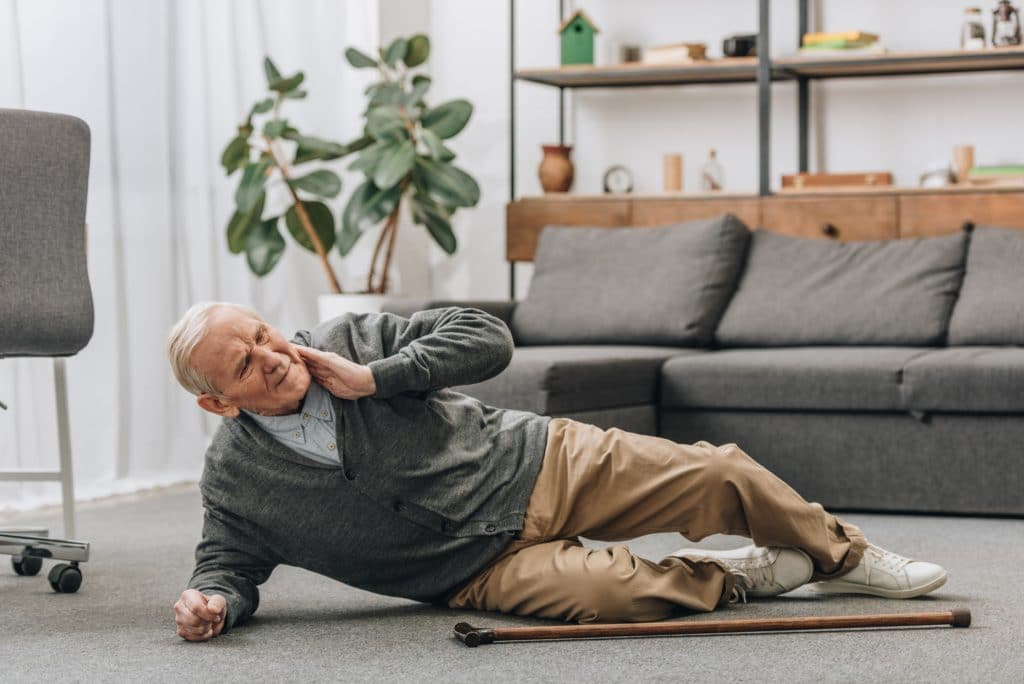 Alter Mann fiel auf den Boden und berührt seinen Nacken