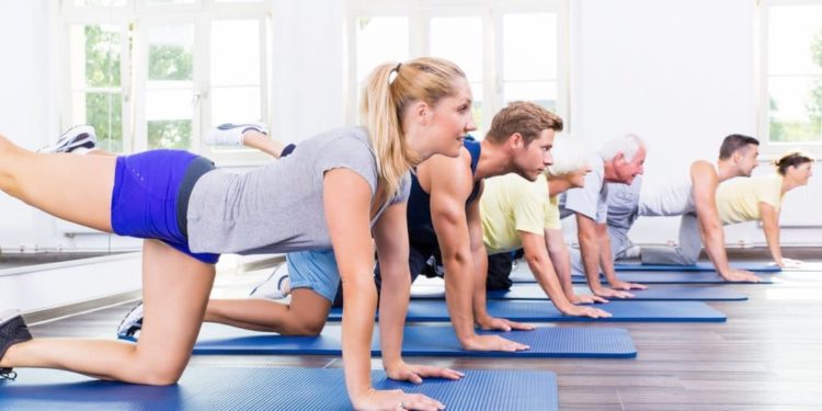 Mehrere Personen kniend beim Sportkurs