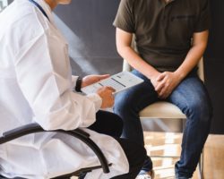 Arzt und Patient sitzen auf Stühlen und unterhalten sich