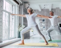 Ein älteres Paar macht Yoga daheim