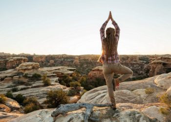Frau macht Yoga auf einem Berg