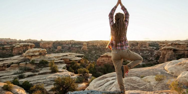 Frau macht Yoga auf einem Berg