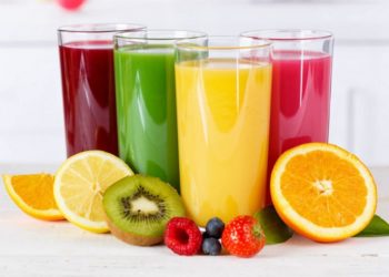 4 Gläser mit Säften in unterschiedlichen Farben und Obst
