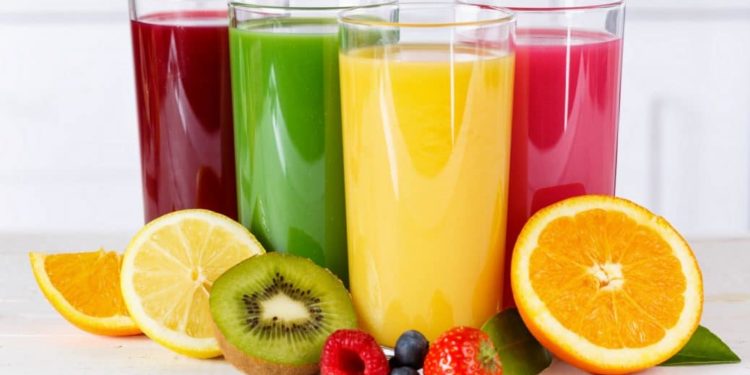 4 Gläser mit Säften in unterschiedlichen Farben und Obst