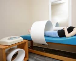 Junge Frau liegt und bekommt eine Magnetfeldtherapie