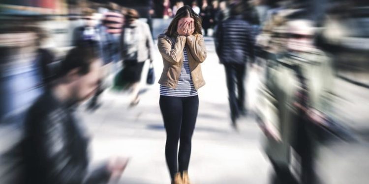 Fokussierung einer Frau, die in einer Menge steht und sich die Hände vor das Gesicht hält