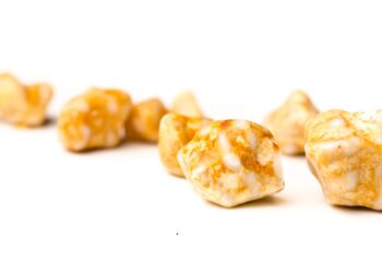 Gelbe Gallensteine verschiedener Größen vor weißem Hintergrund