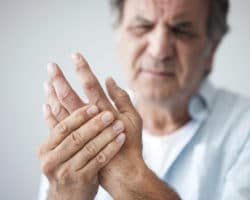 Ein Mann fasst sich an die schmerzende Hand