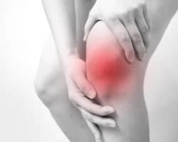 Person fasst sich ans schmerzende Knie
