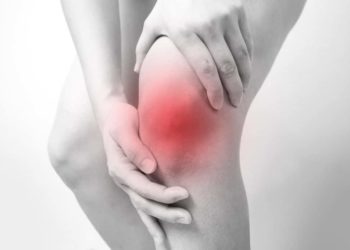 Person fasst sich ans schmerzende Knie