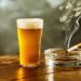 Volles Glas Bier und und brennende Zigaretten im Aschenbecher