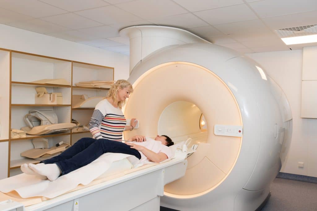 Patientin wird in Kernspintomographen geführt