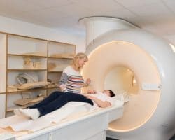Patientin wird in Kernspintomographen geführt
