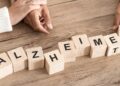 Das Wort Alzheimer als Schriftzug aus Holzblöcken mit Buchstaben gelegt.