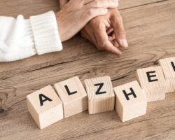 Das Wort Alzheimer als Schriftzug aus Holzblöcken mit Buchstaben gelegt.