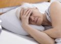 Ältere Frau liegt müde im Bett