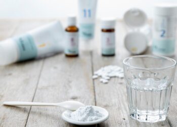 Schüßler-Salze in verschiedenen Darreichungsformen wie Pulver, Tabletten, Salbe sowie ein Glas Wasser