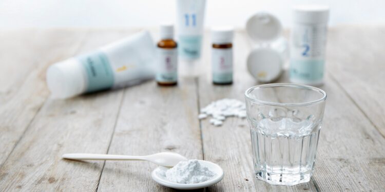 Schüßler-Salze in verschiedenen Darreichungsformen wie Pulver, Tabletten, Salbe sowie ein Glas Wasser