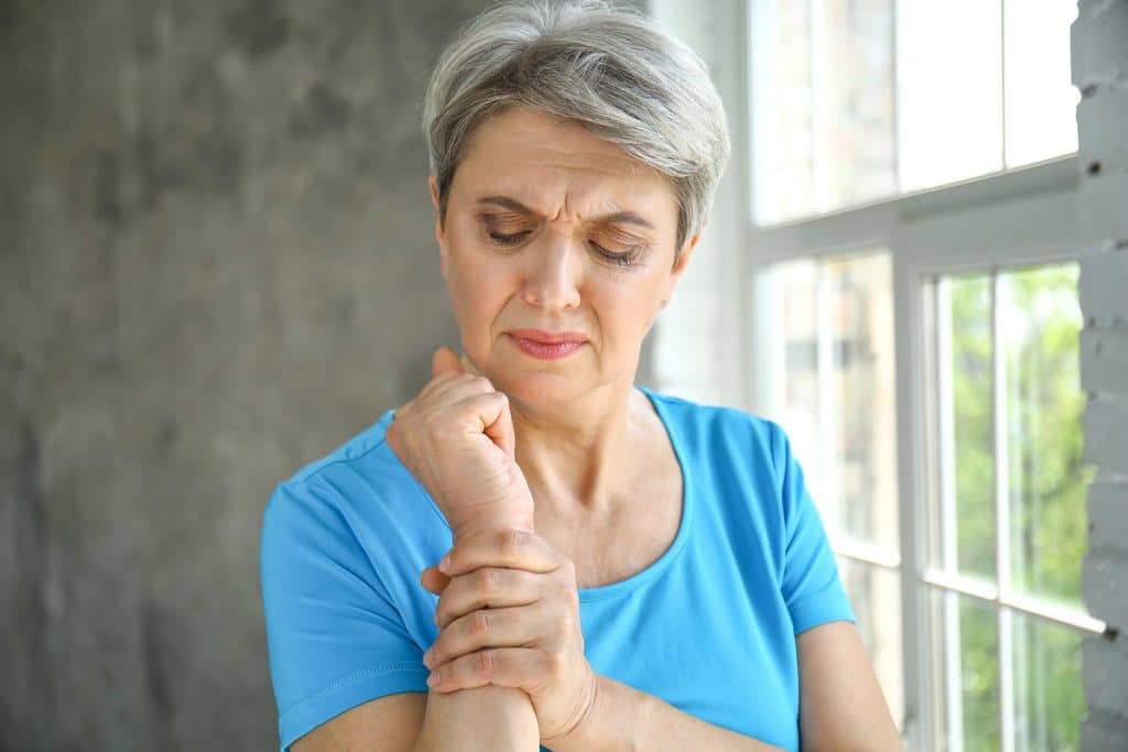 Frau hält schmerzendes Handgelenk