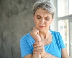 Frau hält schmerzendes Handgelenk