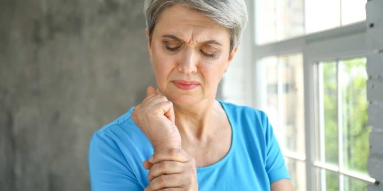 Frau hält schmerzendes Handgelenk