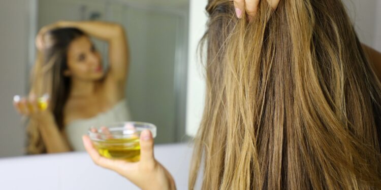 Frau vor einem Spiegel mit Olivenöl-Haarkur