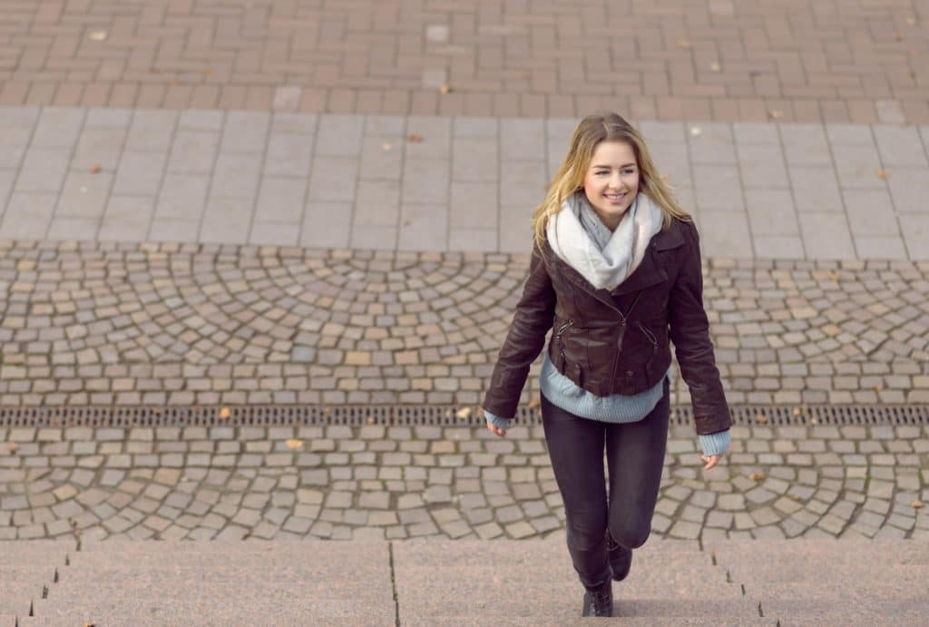 Junge Frau steigt Treppe hoch.
