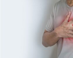 Mann fasst sich ans Herz