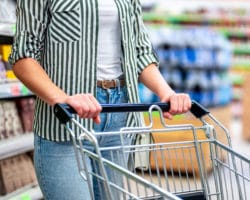 Frau schiebt Einkaufswagen im Supermarkt