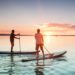 Zwei Männer beim Stand-up-paddling auf einem See