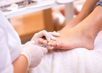 Podologin behandelt den Fuß eine Patientin.