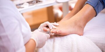 Podologin behandelt den Fuß eine Patientin.
