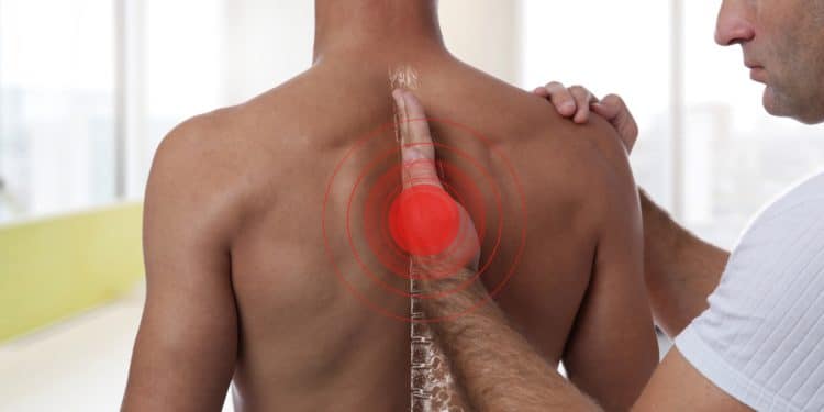 Ein Chiropraktiker behandelt die Wirbelsäule eines Mannes.