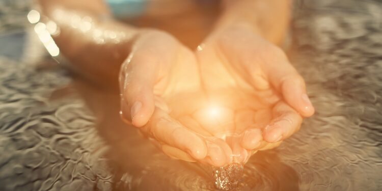 Mit Wasser gefüllte, von der Sonne beschienene Hände