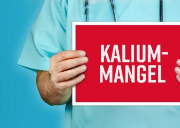 Arzt hält ein rotes Schild mit der Aufschrift Kaliummangel.