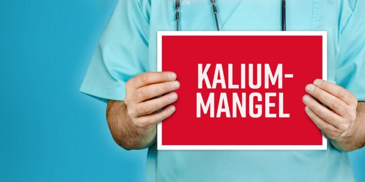 Arzt hält ein rotes Schild mit der Aufschrift Kaliummangel.